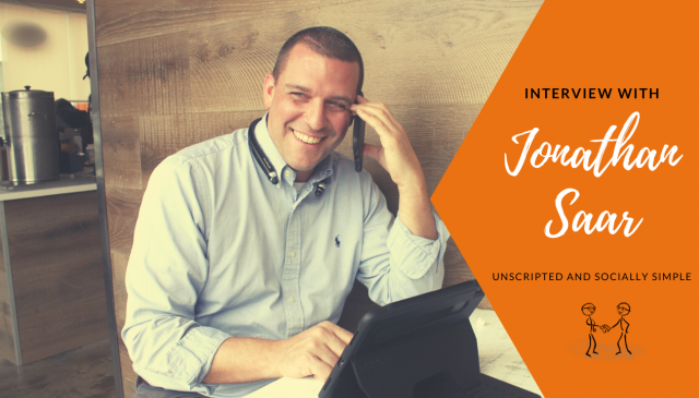 Interview with Jonathan Saar - Unscripted and Socially Simple-Jonathan on his phone smiling.